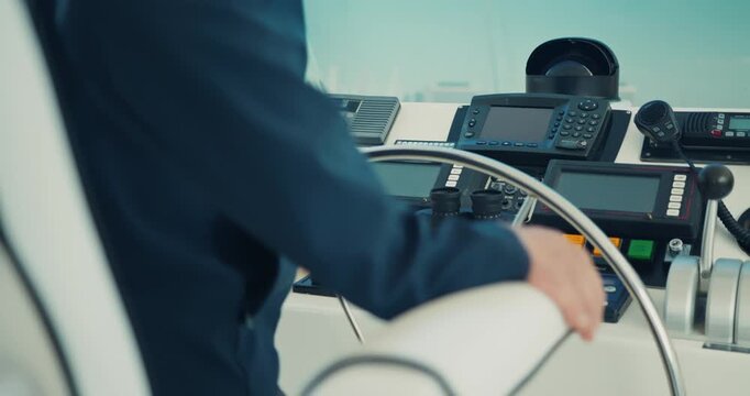 Person Steering Yacht in Control Cabin