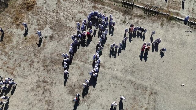 Cinematic aerial view of school children playing in Skardu Valley, northern Pakistan