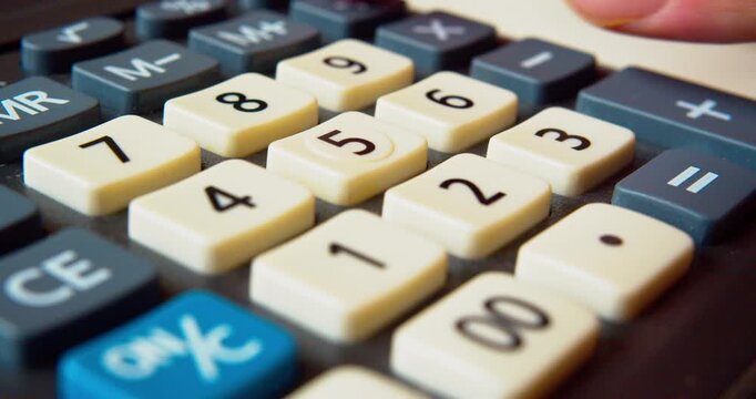 Finger pressing buttons on a calculator, close-up shot.Business concept.