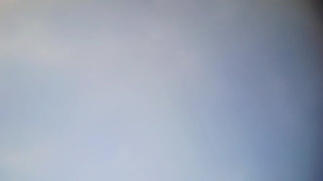 Cinematic timelapse of fluffy white clouds moving across a clear blue sky. Beautiful horizontal shot of bright, clean, and sunny atmosphere during a peaceful day. This footage captures the natural.