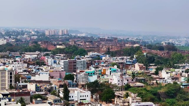 Aerial view of bidar fort with residential buildings, signal tower, trees, fog and sky, at karnataka, india. day time, push in shot, drone shot, 4k.