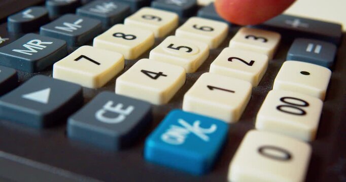 Finger pressing buttons on a calculator, close-up shot.Business concept.