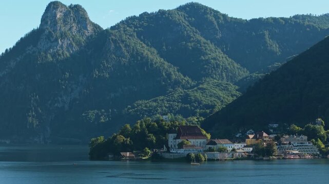 Aerial view of Traunkirchen church and majestic Alpine mountain range, Austria