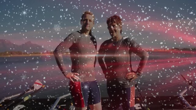 Two sportswomen standing on dock over mountain lake after 2s red flare sweeping flakes swirling