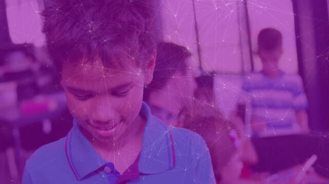Boy finishing worksheet and lifting head toward camera, sharing friendly smile in classroom