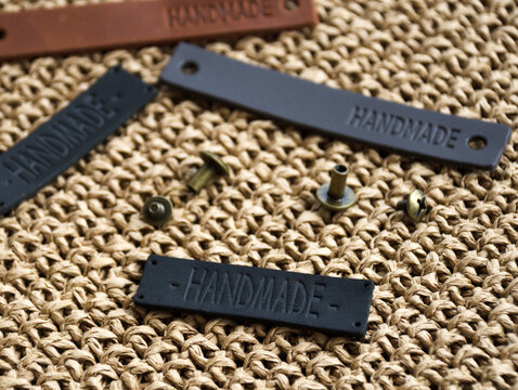 Handmade labels on a raffia knitted textured background. Raffia crochet texture and lots of handmade tags. ECO material Raffia.