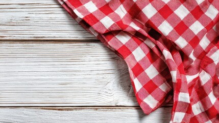 Obraz premium Spring Summer outdoor leisure relaxation activity. A closeup of a red and white checkered tablecloth draped over a weathered wooden surface. The tablecloths texture is visible.