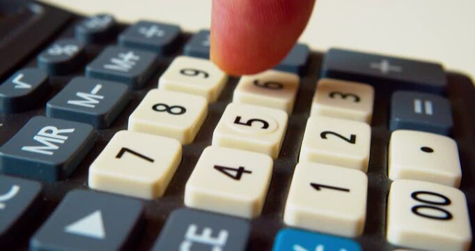 Finger pressing buttons on a calculator, close-up shot.Business concept.