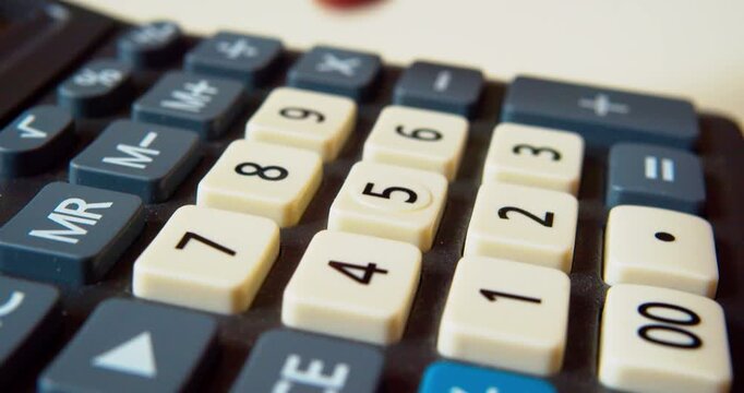 Finger pressing buttons on a calculator, close-up shot.Business concept.