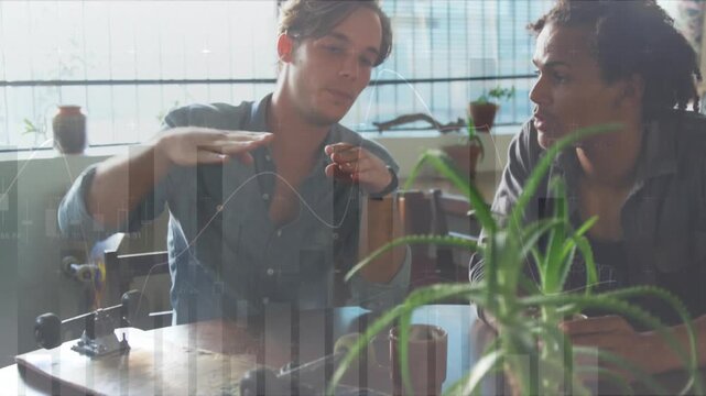 The four friends are sitting at a table in a restaurant, interacting with each other