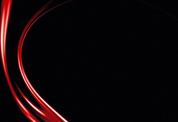 Fototapeta premium Abstract red light trails curving on dark background, futuristic motion and energy