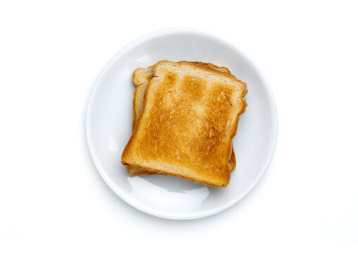 Toast bread slices on white plate top view isolated on white background