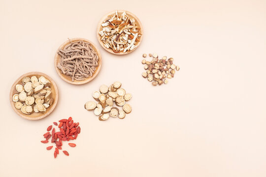 Various traditional Chinese medicinal herbs arranged flatly including goji berries and astragalus
