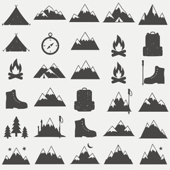 Collection of silhouette icons representing mountain expeditions, including tents, boots, backpacks, and campfires for outdoor adventure themes © Mona