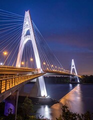 Fototapeta premium Stunning Night View of a Modern Cable-Stayed Bridge Illuminated Over a River.