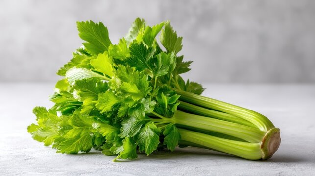 Fresh celery stalk and leaves on a light background