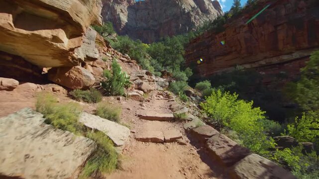 Footage of a hiker's perspective on the scenic Watchman Trail in Zion National Park, Utah. This popular, moderate trail offers stunning views of the canyon and Springdale area, winding through red roc