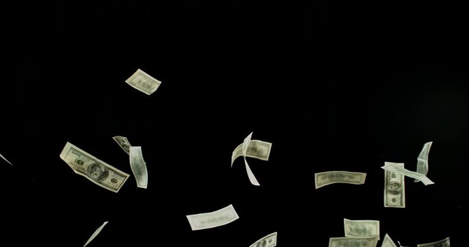 US dollar banknotes flying in super slow motion against black background. Floating money bills drifting and falling in the air, symbolizing wealth, finance and luxury in cinematic detail.
