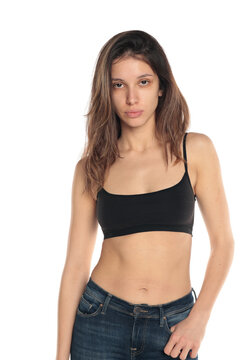 Studio shot of a young woman with natural skin and no makeup wearing a black top, calm neutral expression, portrait on white background