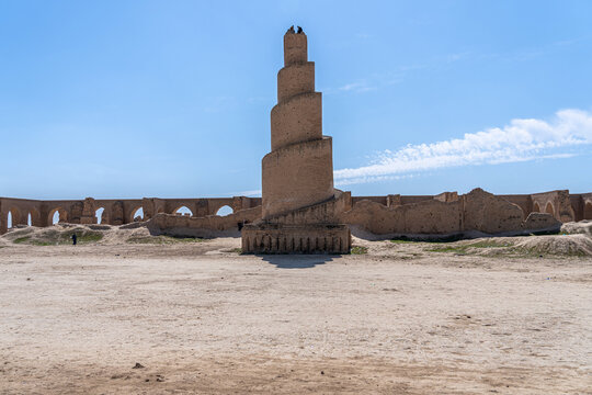 A striking minaret, built with layered brickwork, commands attention against the vibrant blue sky in Abu Dulaf, Iraq