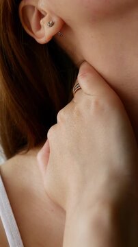 Close-up of woman rubbing neck to relieve pain and discomfort, self-massage for tension relief.