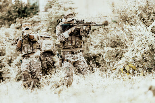 Tactical military units in action during a training exercise in natural terrain