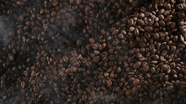 Industrial coffee roasting process, beans tumbling and cooling in roaster, top view.