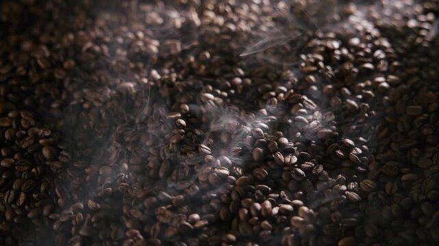 Roasting process of coffee beans with smoke, dark mood with light.