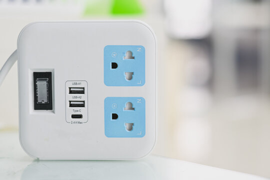 A white power strip with USB and charging ports.