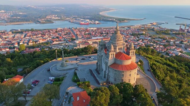 Scenic drone perspective approaching the Sanctuary of Santa Luzia with the harbor of Viana do Castelo, Portugal at dusk. Push in approach dolly shot