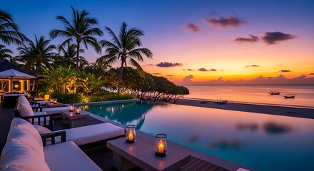 Fototapeta premium Luxurious tropical resort with an infinity pool overlooking the ocean at a vibrant sunset, featuring palm trees and illuminated lounge areas.