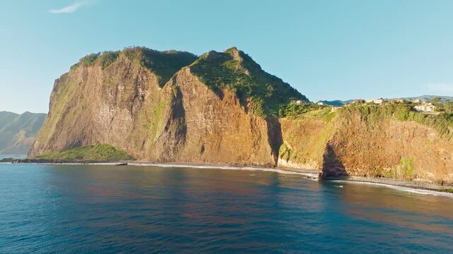 Aerial view of Madeira cliffs coastline landscape on sunrise, Guindaste viewpoint, Madeira island, Portugal. Orbit parallax shot