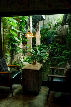 Table and chair set in garden on a sunny day,outdoor seating for restaurant or cafe,Neat paved patio with sitting area and small garden in forest.