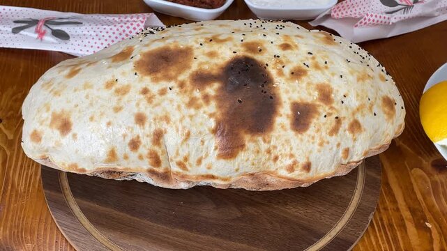 Puffed bread on a wooden board with toasted spots ideal for culinary background images
