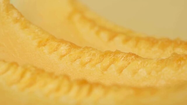 Extreme Macro Close-up of Fresh Juicy Cantaloupe Melon Slices with Ridged Texture on Orange Background, Food Ads
