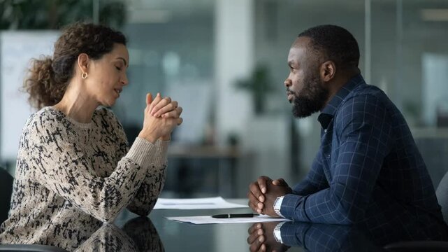 Medium shot of a finance consultant discussing multiunit franchise credit options with a client sharp focus on consultants gestures blurred office background.