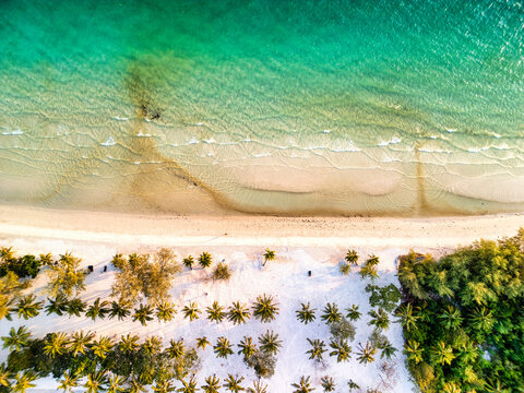 Aerial view of the serene beach meeting the lush tropical forest, a captivating blend of turquoise waters and verdant greens, Preah Sihanouk, Sihanoukville, Cambodia.