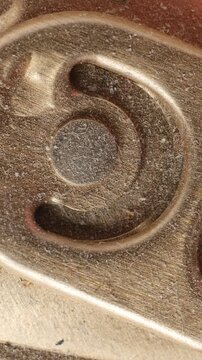 Extreme macro of aluminum beverage can pull tab rotating, metallic detail. Vertical