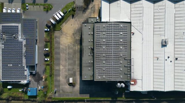 Aerial view of rooftops featuring varied textures, from ribbed metal to solar panels, creating a compelling industrial landscape, Ganshoren, Brussels, Belgium.