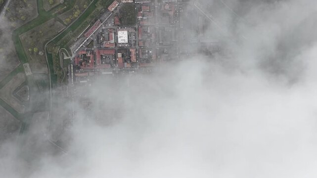 Aerial view of the star-shaped city of Neuf-Brisach, partially obscured by a blanket of thick fog, creating a surreal landscape, Neuf-Brisach, Grand Est, France.