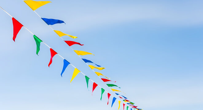 Colorful pennant flags against a clear blue sky background