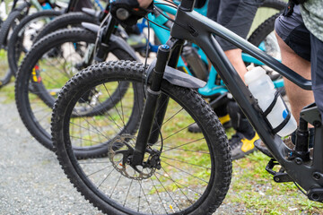 Fototapeta premium Group of mountain bikes lined up with riders ready for off-road cycling on a gravel trail