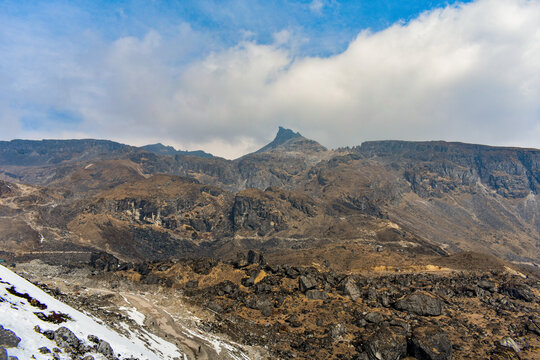 Rugged rocky Himalayan peaks under dramatic clouds, high-altitude landscape at North Sikkim, India.