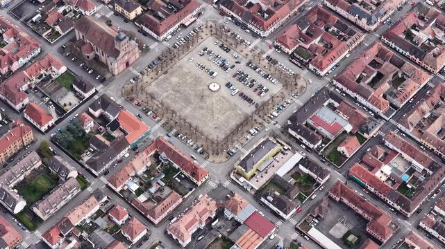 Aerial view of the Church and the Square, showcasing the symmetrical layout of the city, with red-roofed buildings and a large parking lot, Neuf-Brisach, Grand Est, France.