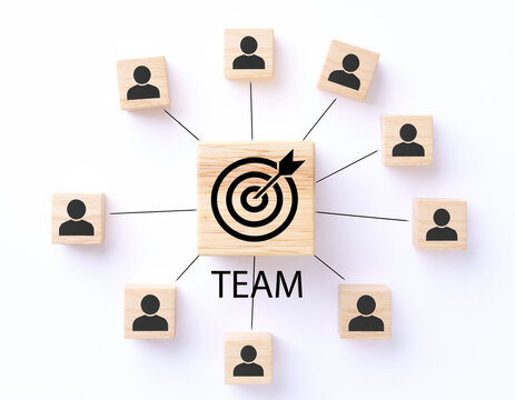 teamwork concept with connected wooden blocks showing people icons and central target symbol representing collaboration leadership communication strategy and goal alignment in modern business