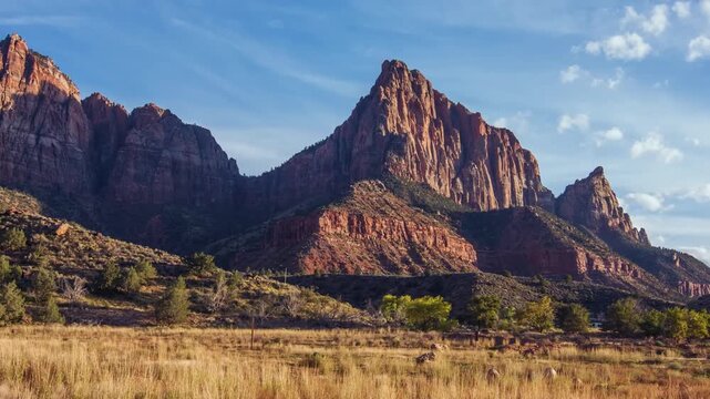 A view of The Watchman, a prominent sandstone mountain peak in Zion National Park, Utah, USA, as seen from the Watchman Trail area. The image captures the massive rock formation with its striated red 