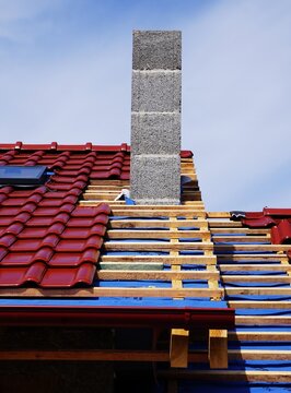 Budowa domu, elegancka dach&oacute;wka na dachu, deski z wierzby, zamontowany komin, słoneczna pogoda