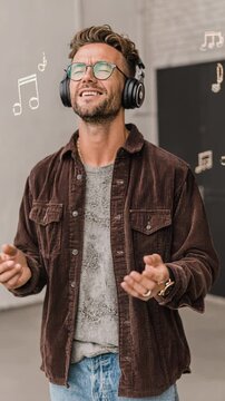 Man enjoying via over ear headphones, musical notes floating around, relaxed expression, casual streetwear, immersion experience.