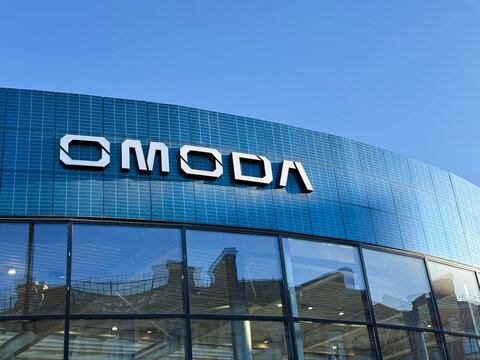 The facade of the car shop Omoda on the background of the blue sky. Omoda is an automobile manufacturer. Chinese Motor Corporation. Omoda Cars in the showroom. Brand owned by Chery, Chinese automaker.