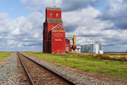 abandoned old grain elevator with modern grain bins in the background , Duval, Saskatchewan, Canada
